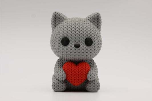3D-printet figur av en grå katt i strikket design som holder et hjerte