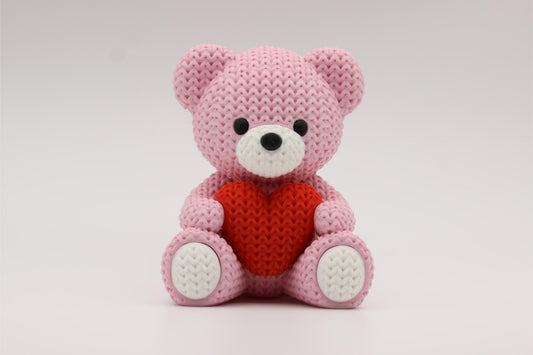 3D-printet figur av en rose teddybjørn i strikket design som holder et hjerte