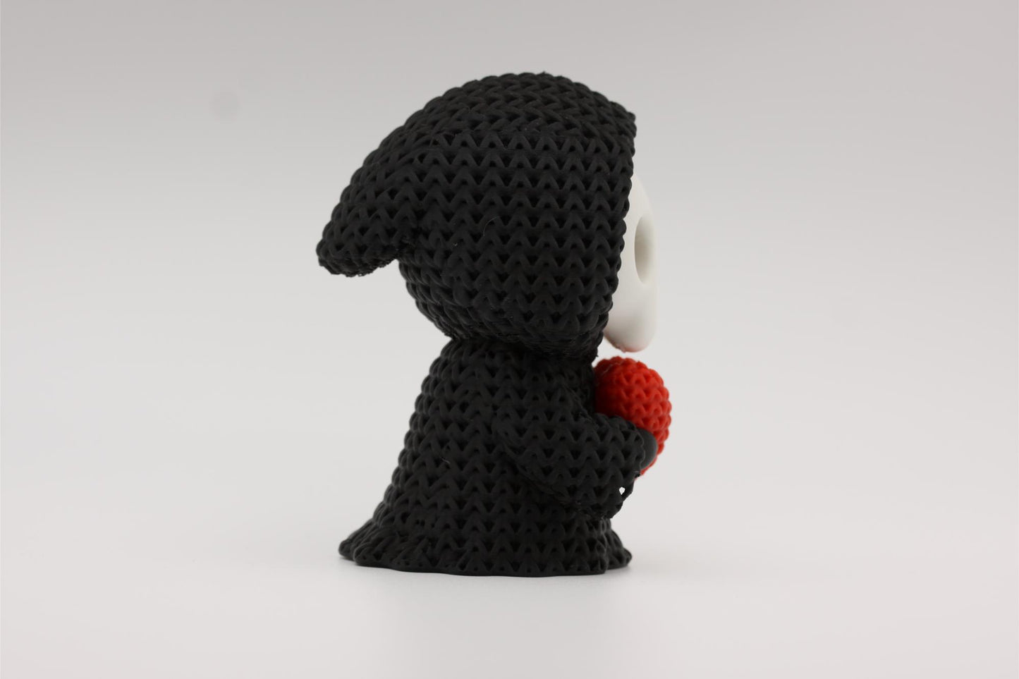 3D-printet figur av Grim reaper i strikket design som holder et hjerte