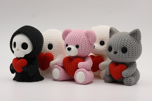 Fem 3D-printede figurer i strikket tema som holder et hjerte
