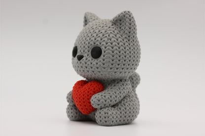 3D-printet figur av en grå katt i strikket design som holder et hjerte