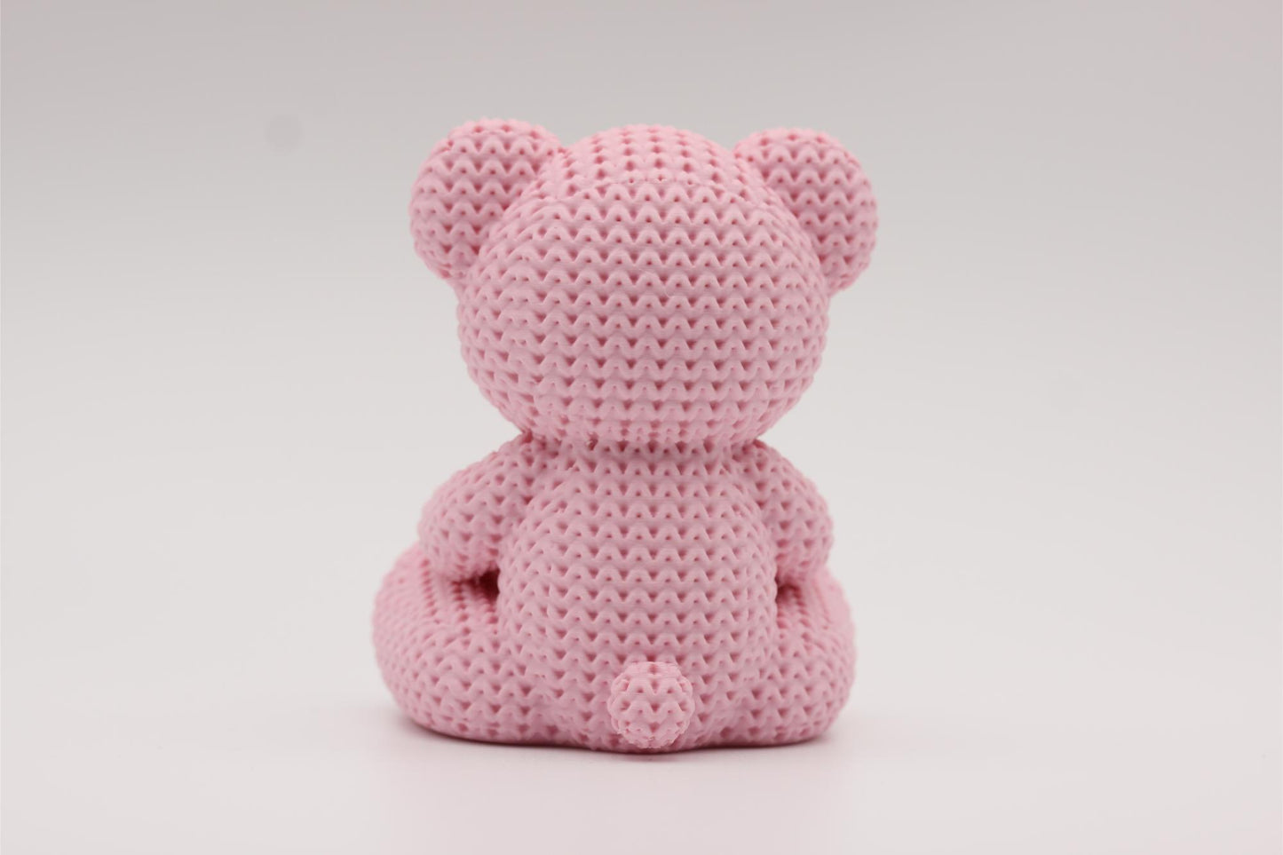3D-printet figur av en rose teddybjørn i strikket design som holder et hjerte