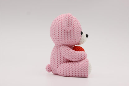 3D-printet figur av en rose teddybjørn i strikket design som holder et hjerte