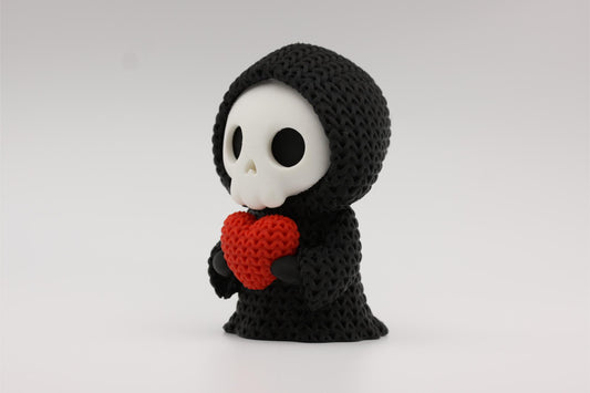 3D-printet figur av Grim reaper i strikket design som holder et hjerte
