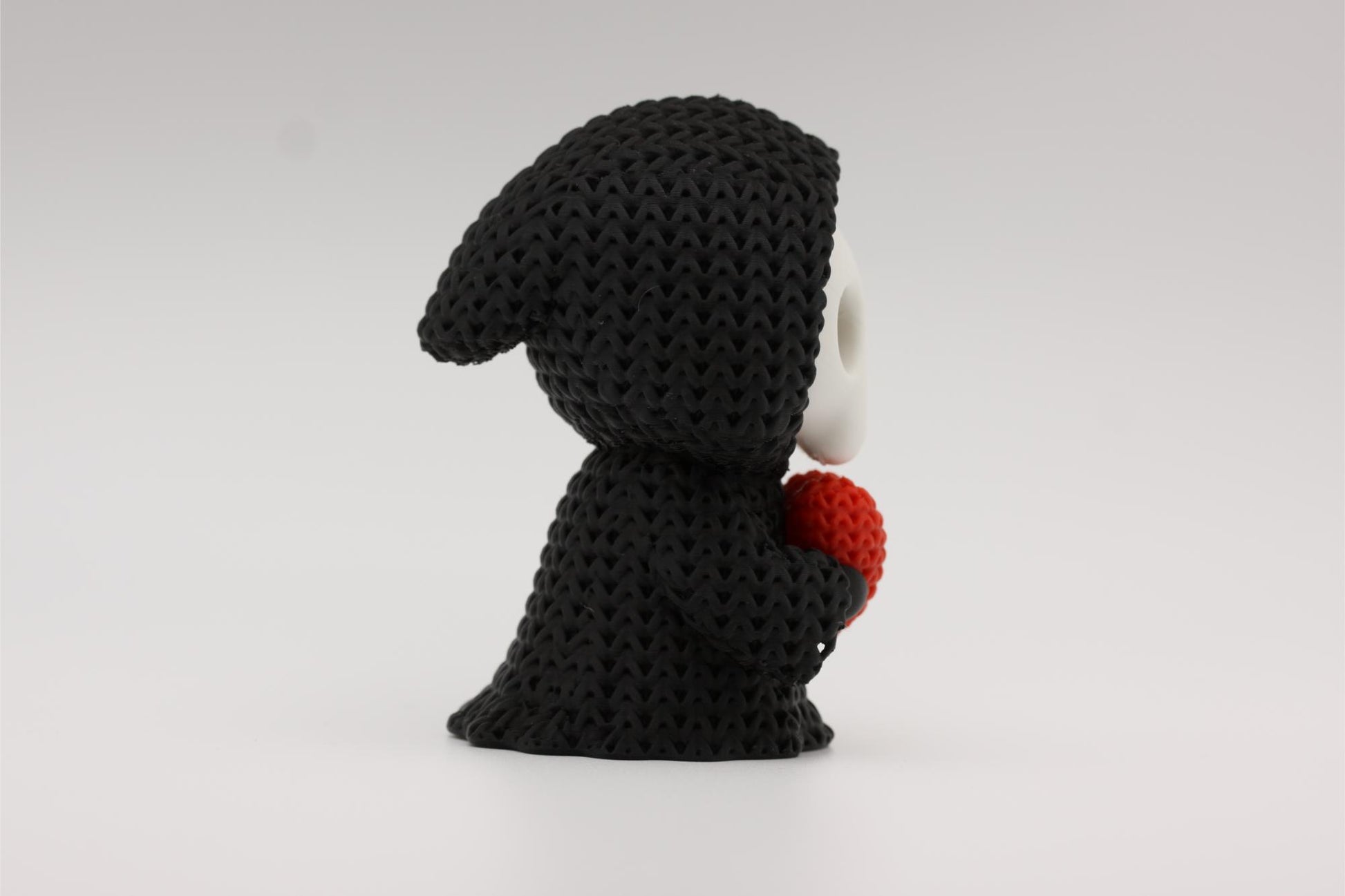 3D-printet figur av Grim reaper i strikket design som holder et hjerte