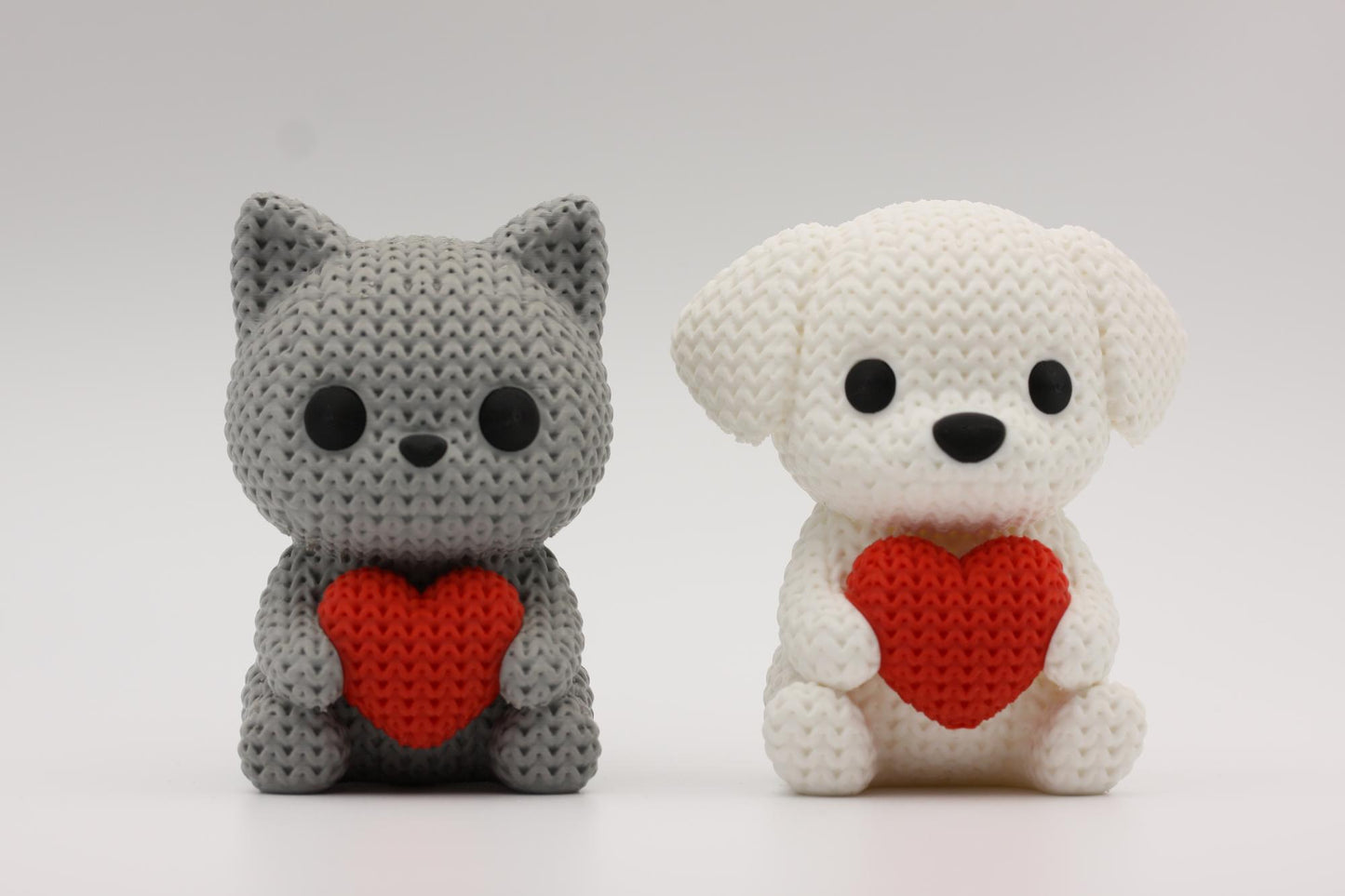 Katt og hund som holder et hjerte 3D-printet i strikket design