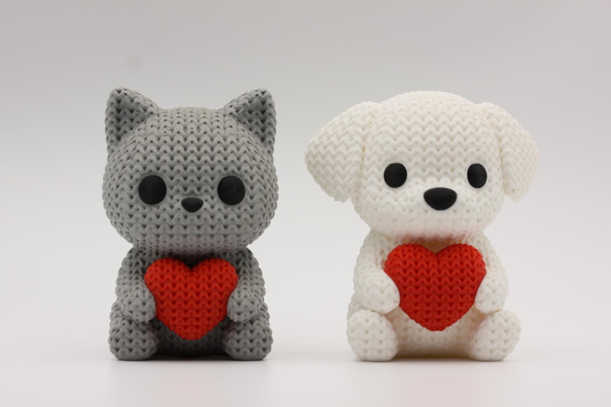 Katt og hund som holder et hjerte 3D-printet i strikket design
