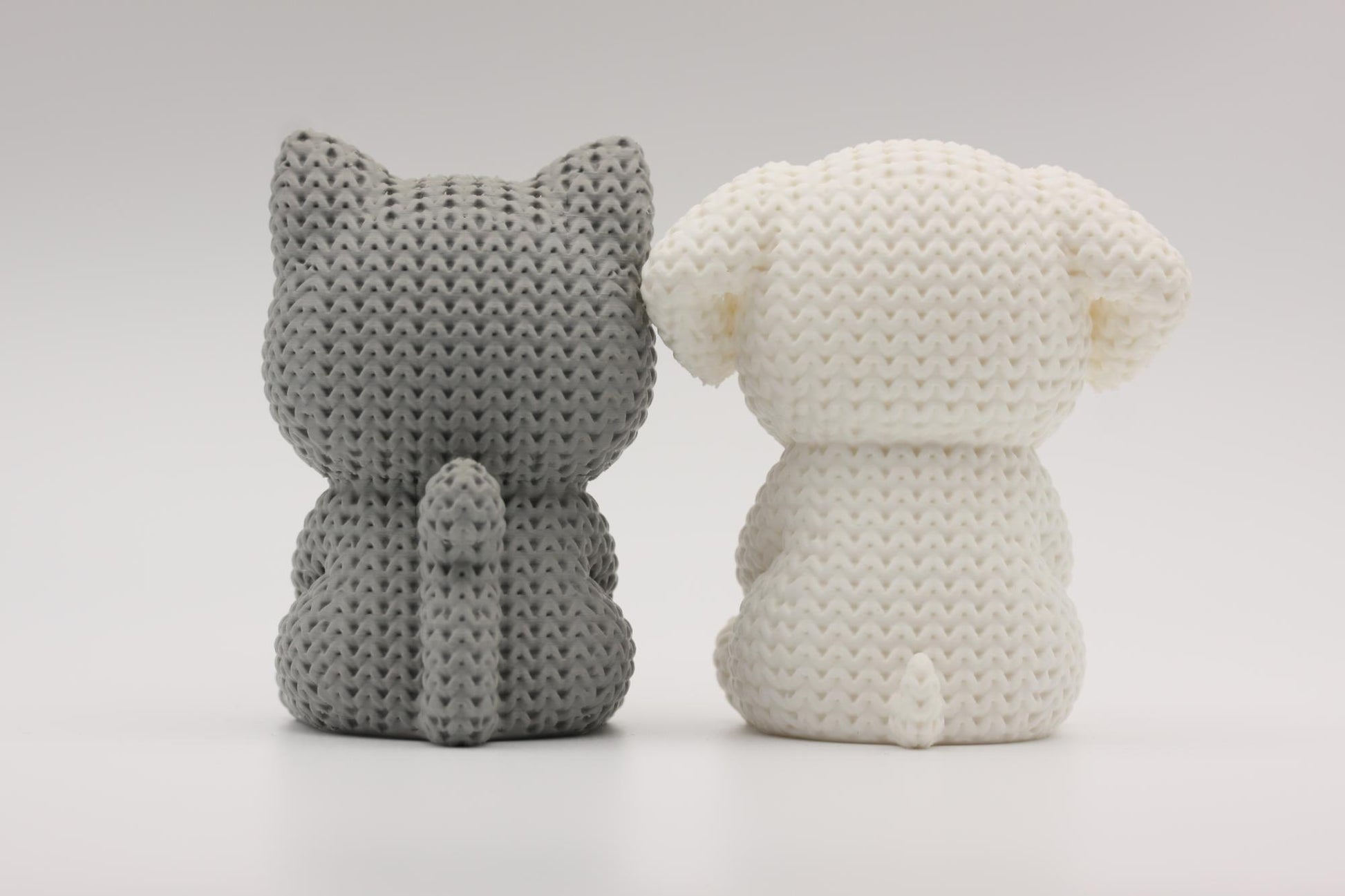 Katt og hund som holder et hjerte 3D-printet i strikket design