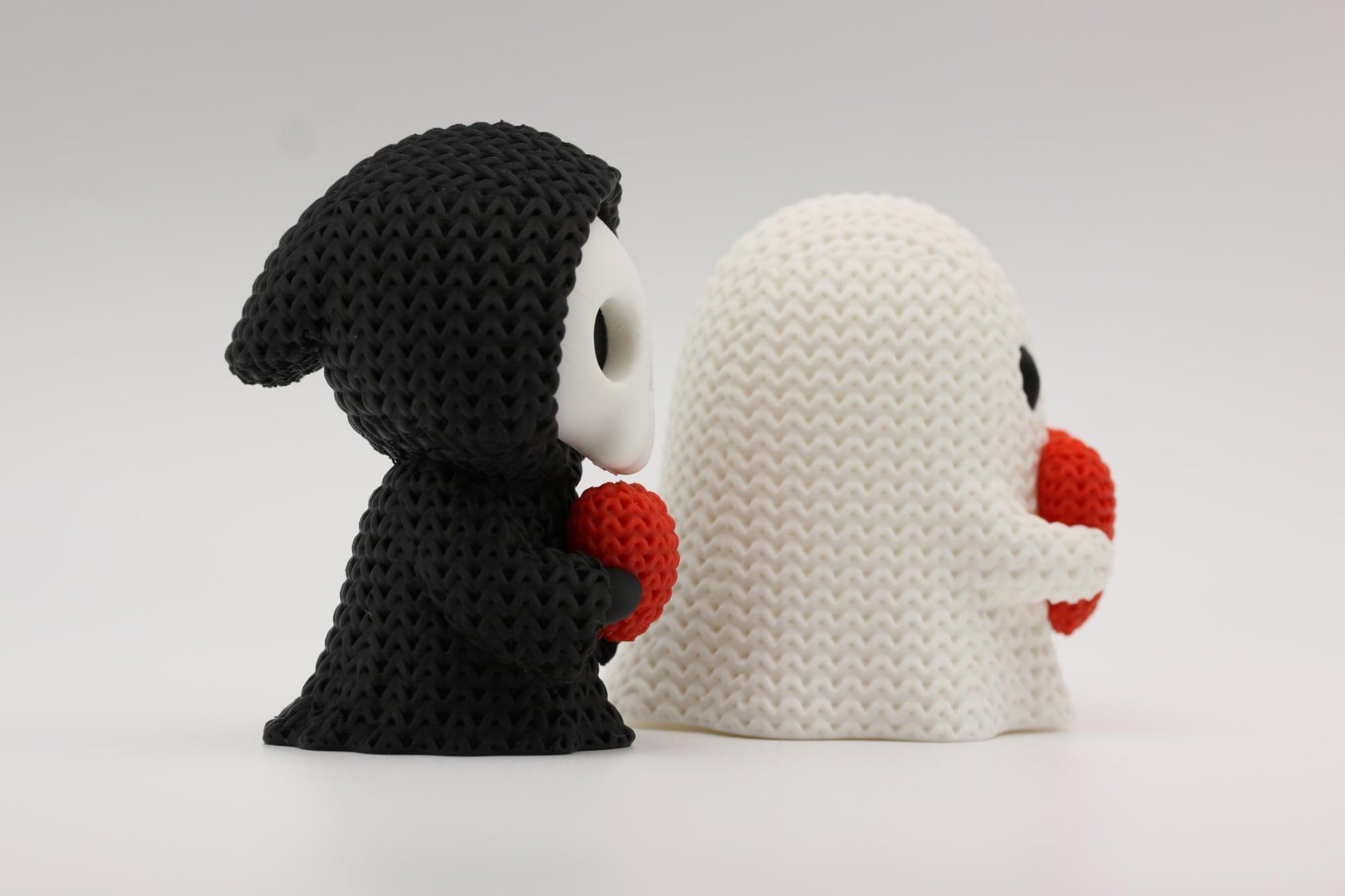 Grim reaper og et spøkelse som holder et hjerte 3D-printet i strikket design