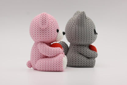 Teddybjørn og katt som holder et hjerte 3D-printet i strikket design
