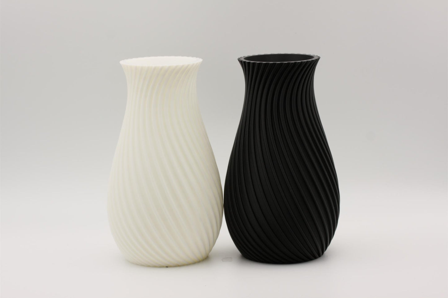 En svart og en hvit vase som er 3D-printet